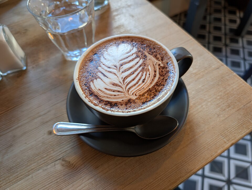 Mocha con arte latte y cacao en polvo espolvoreado sobre la espuma